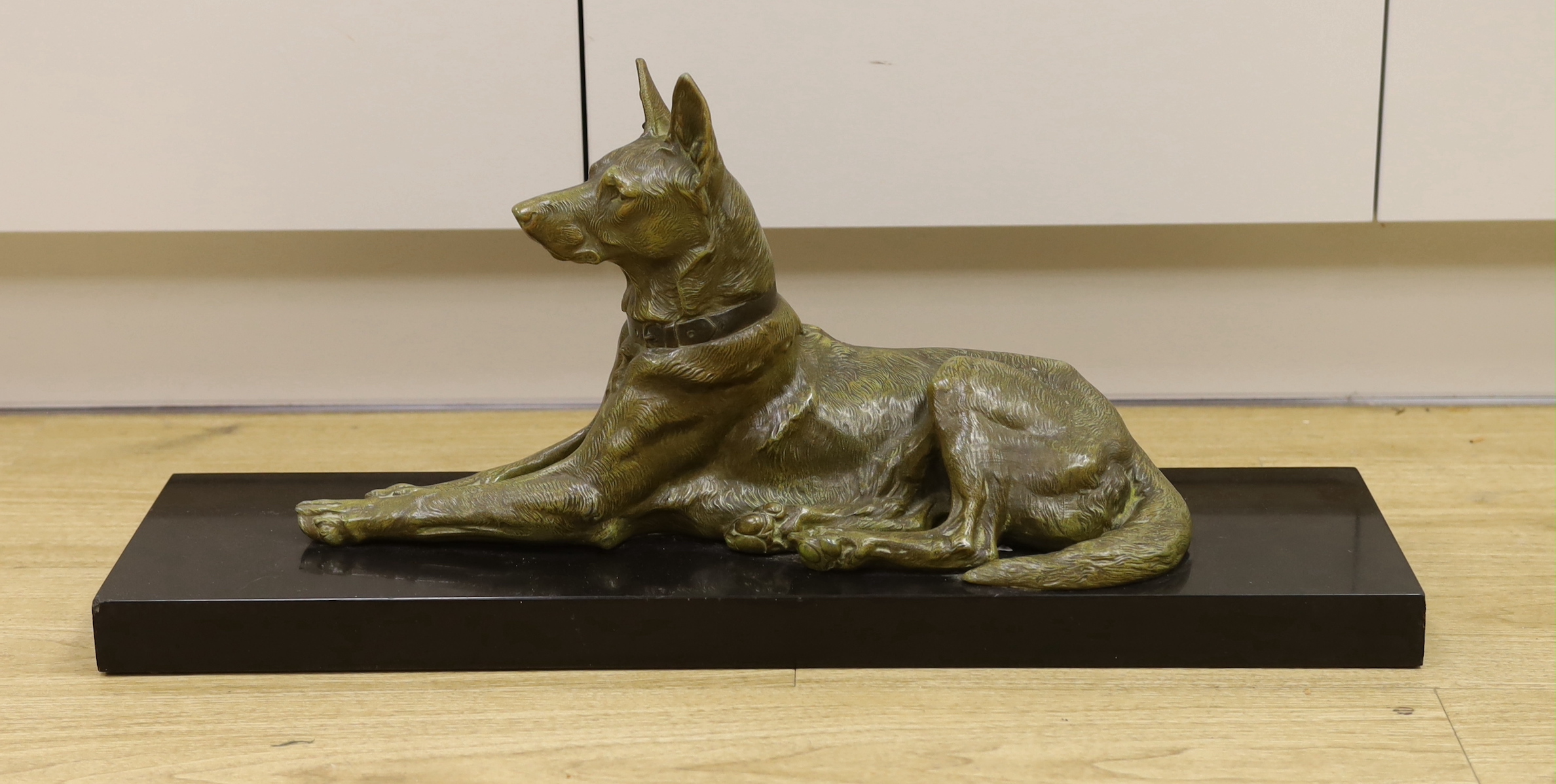 After Maximilien Louis Fiot (1886-1953). A French Art Deco bronzed spelter model of a recumbent German Shepherd, 70cm long